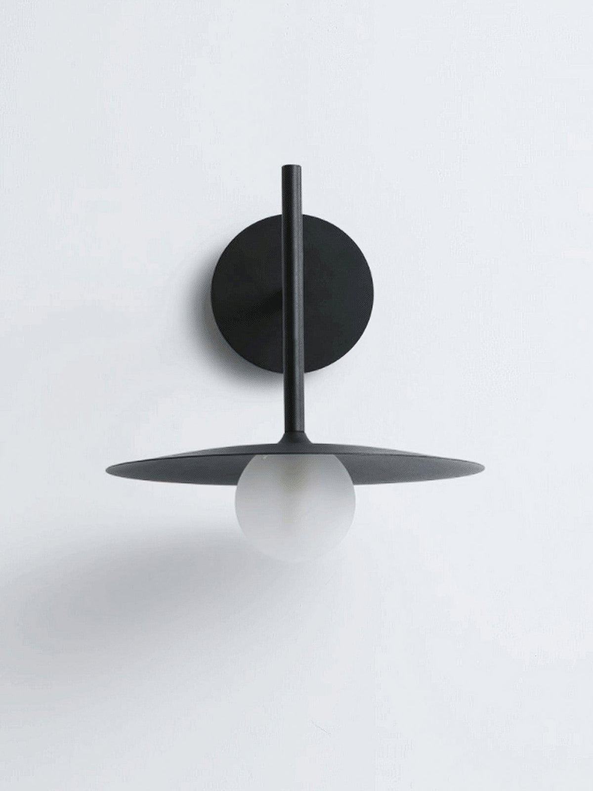 Studio view of this black Clérachic wall light, shown unlit against a plain white backdrop.