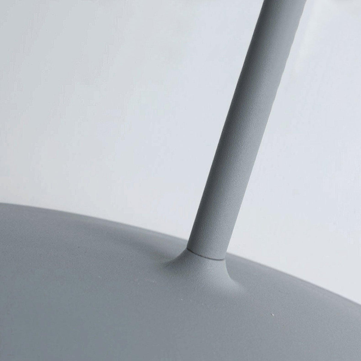 Close view of the angled arm meeting the disc shade on this grey Clérachic wall light.