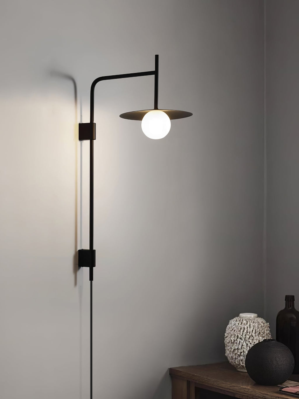 White swing arm wall lamp with frosted glass shade on wall