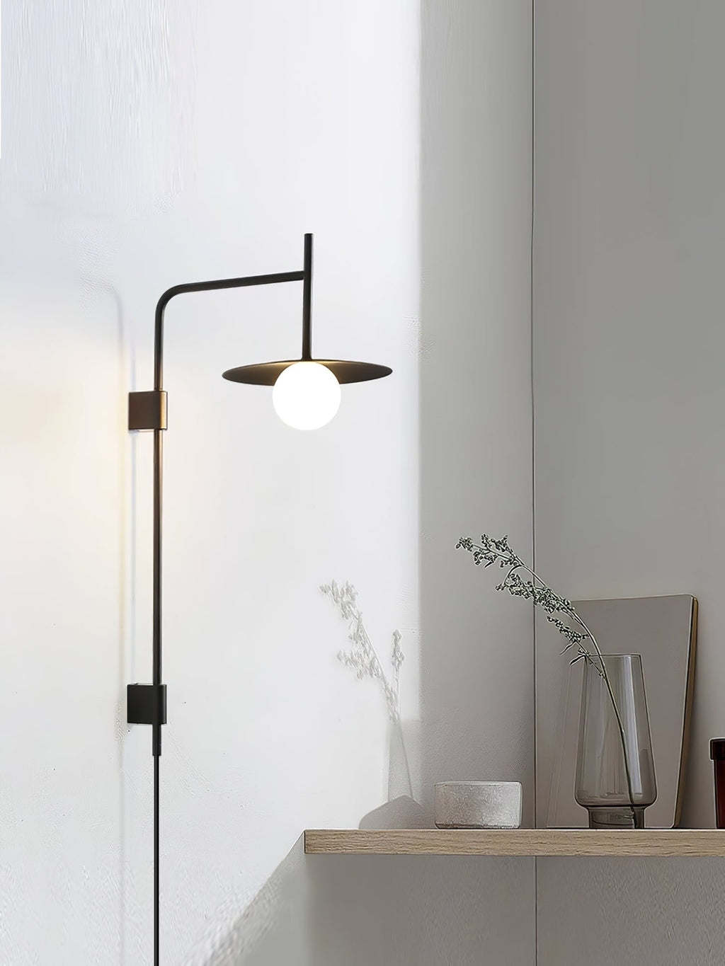 Swing arm wall lamp with frosted glass shade switched on