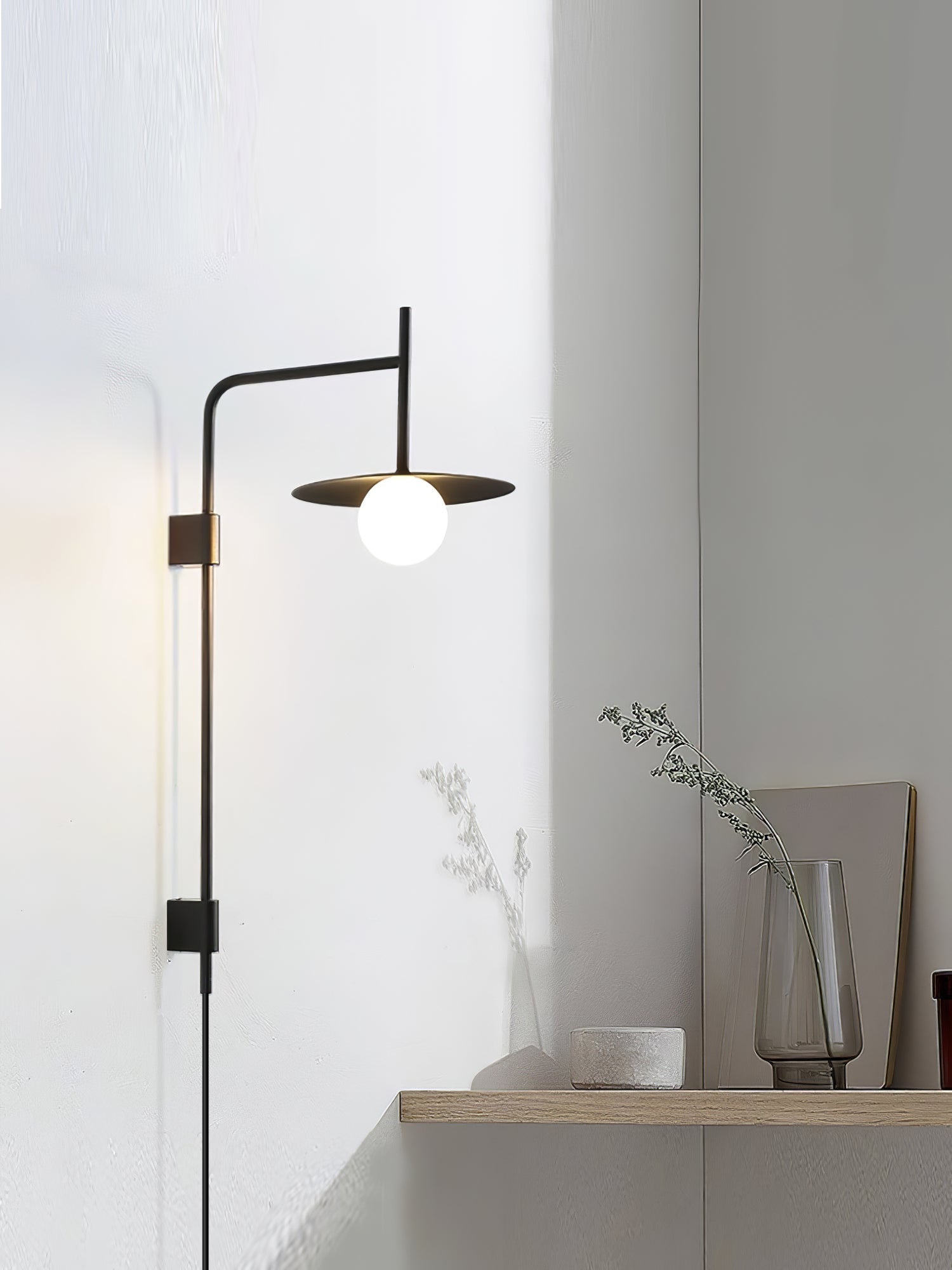 Swing arm wall lamp with frosted glass shade switched on