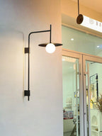 Swing arm wall lamp casting warm light in a bedroom