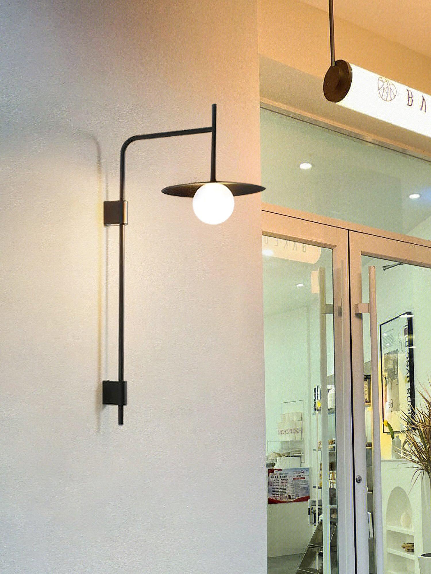 Swing arm wall lamp casting warm light in a bedroom