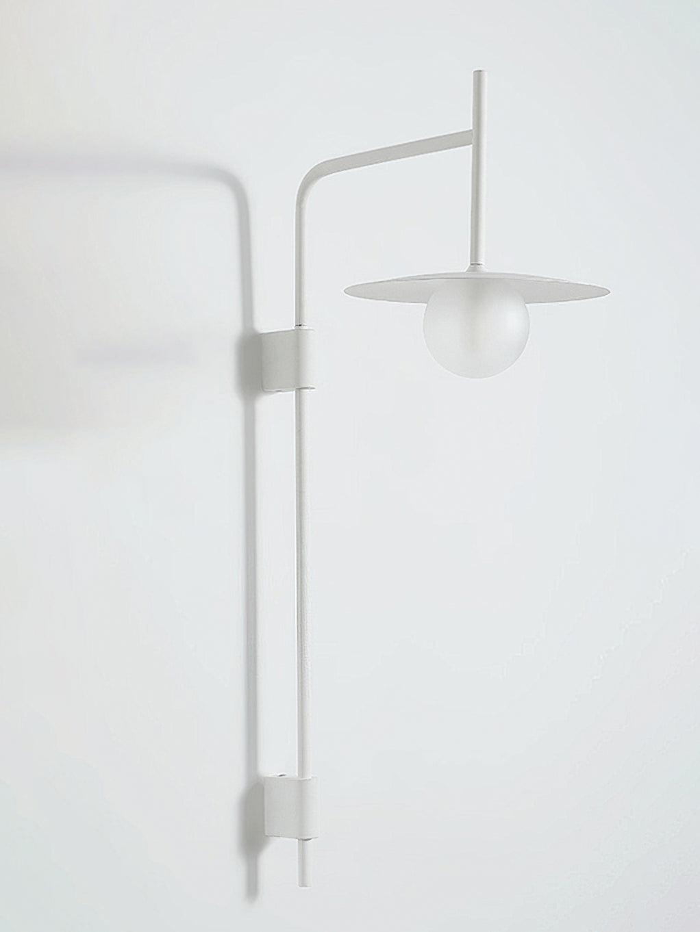 Swing arm wall lamp glowing softly against a neutral wall