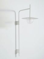 Swing arm wall lamp glowing softly against a neutral wall