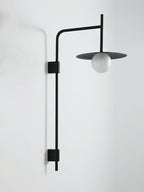 Swing arm wall lamp with frosted glass shade in a quiet nook