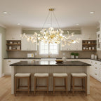 Linear ginkgo leaf chandelier glowing above a dining table