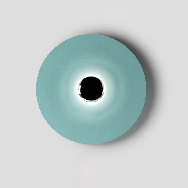 A wider crop reveals more of the pale aqua shade on this Clérachic wall light, its black centre gently lit.