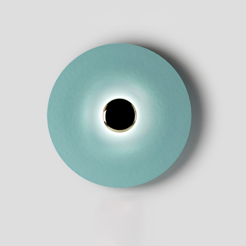 Framed tightly on grey, this pale aqua Clérachic wall light shows a crisp ring of light around its dark core.