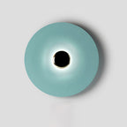 Framed tightly on grey, this pale aqua Clérachic wall light shows a crisp ring of light around its dark core.