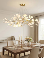 Ginkgo bough chandelier with brass branches lit warmly