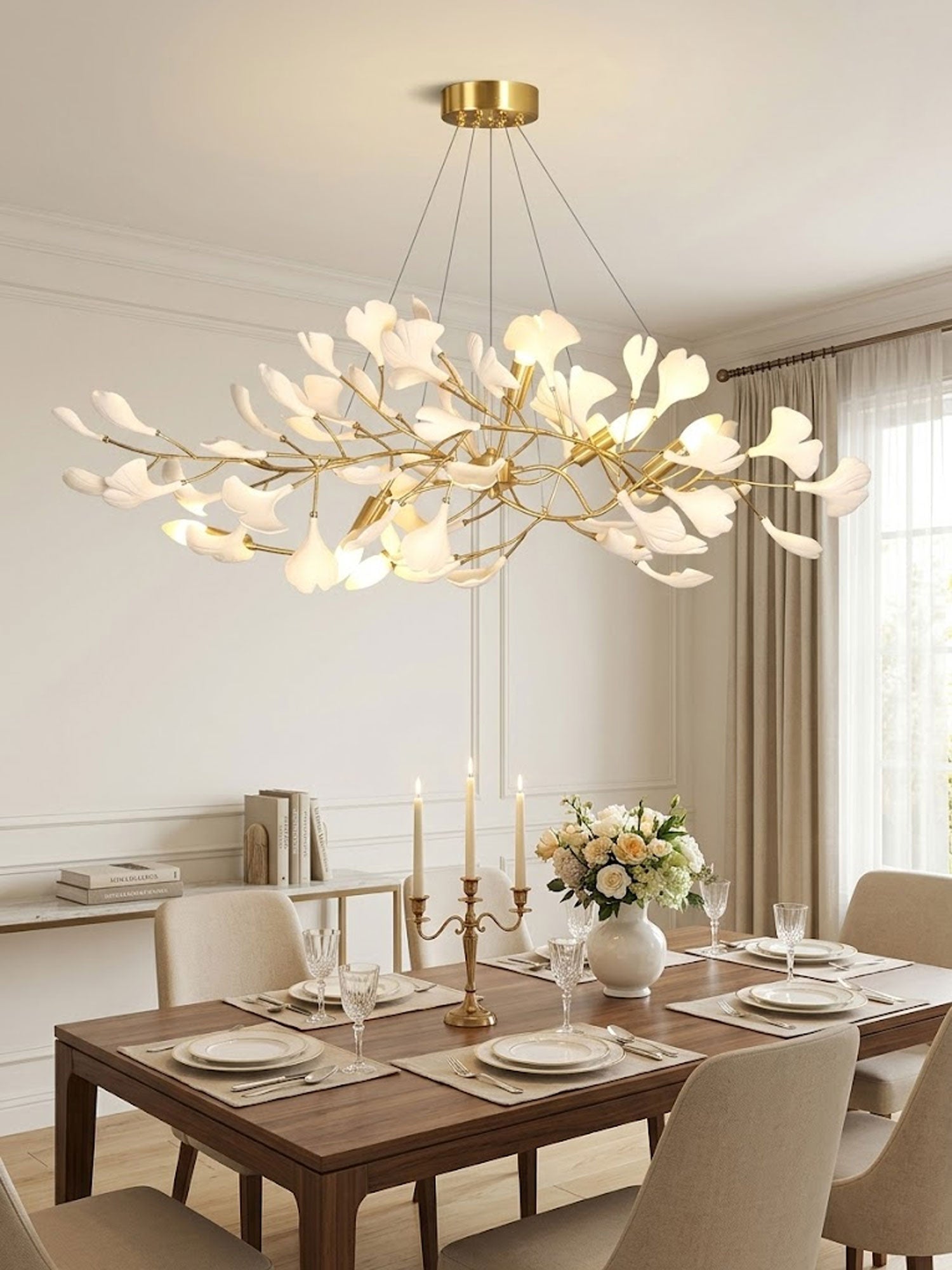 Ginkgo bough chandelier with brass branches lit warmly