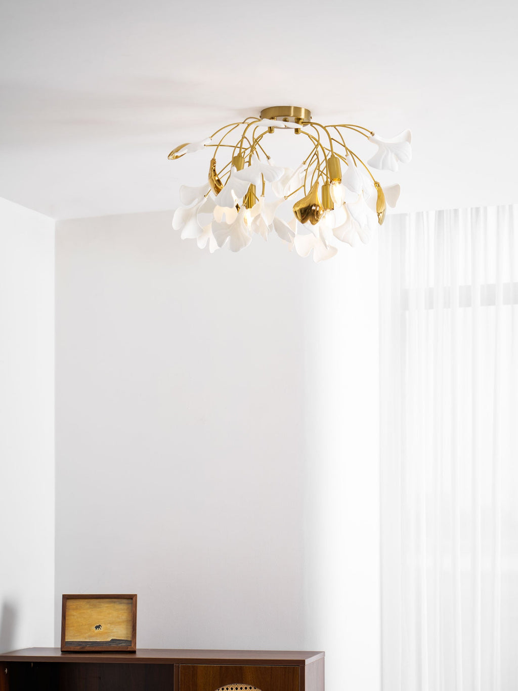 Ceramic ginkgo leaf ceiling light shown lit at night