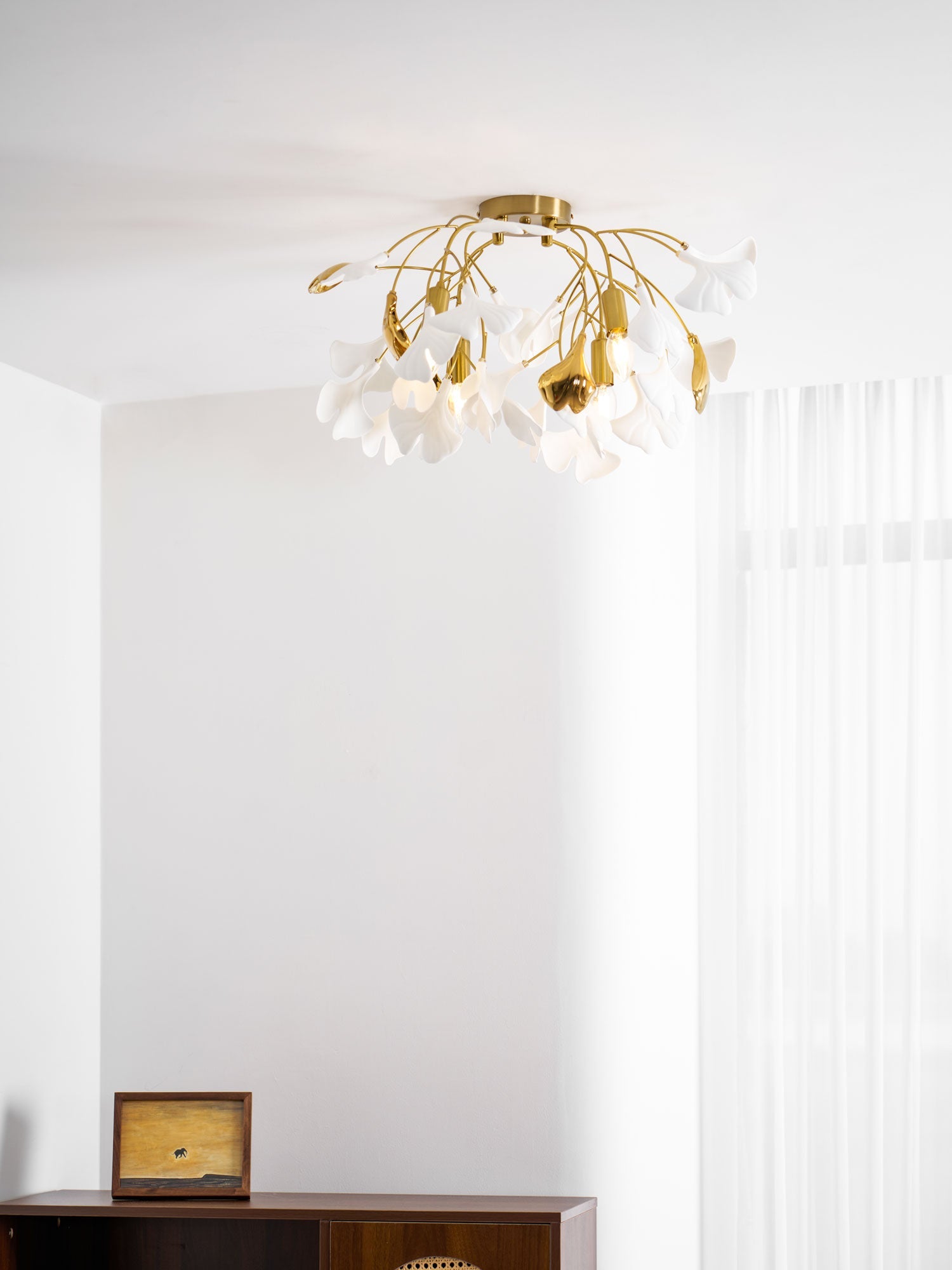Ceramic ginkgo leaf ceiling light shown lit at night