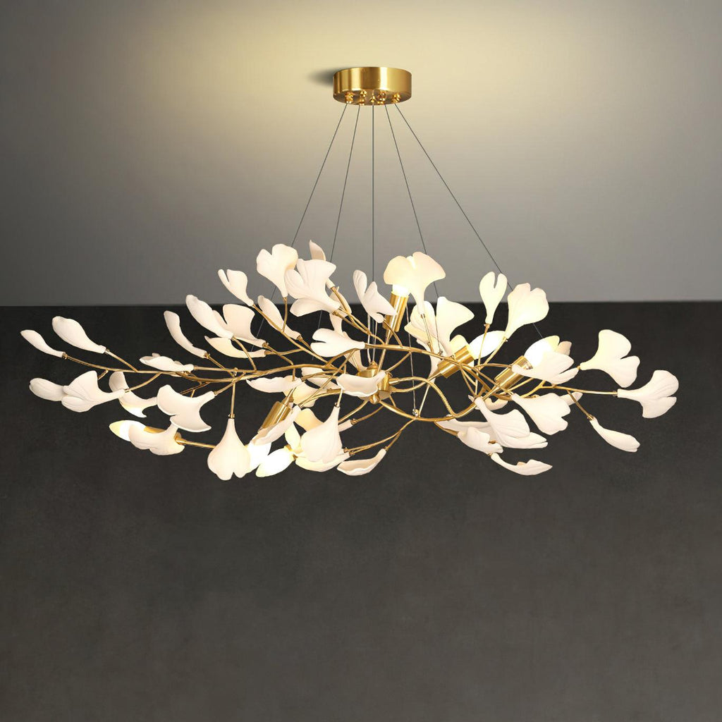 Linear ginkgo chandelier lit warm above a long table