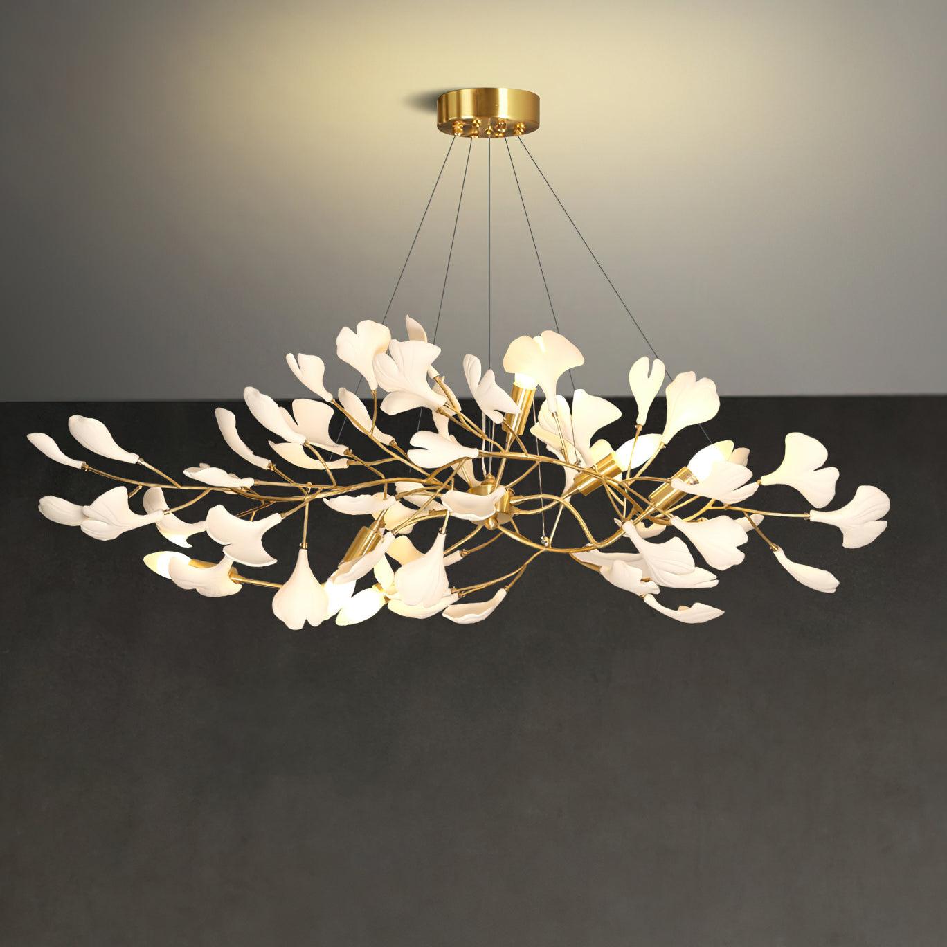 Linear ginkgo chandelier lit warm above a long table