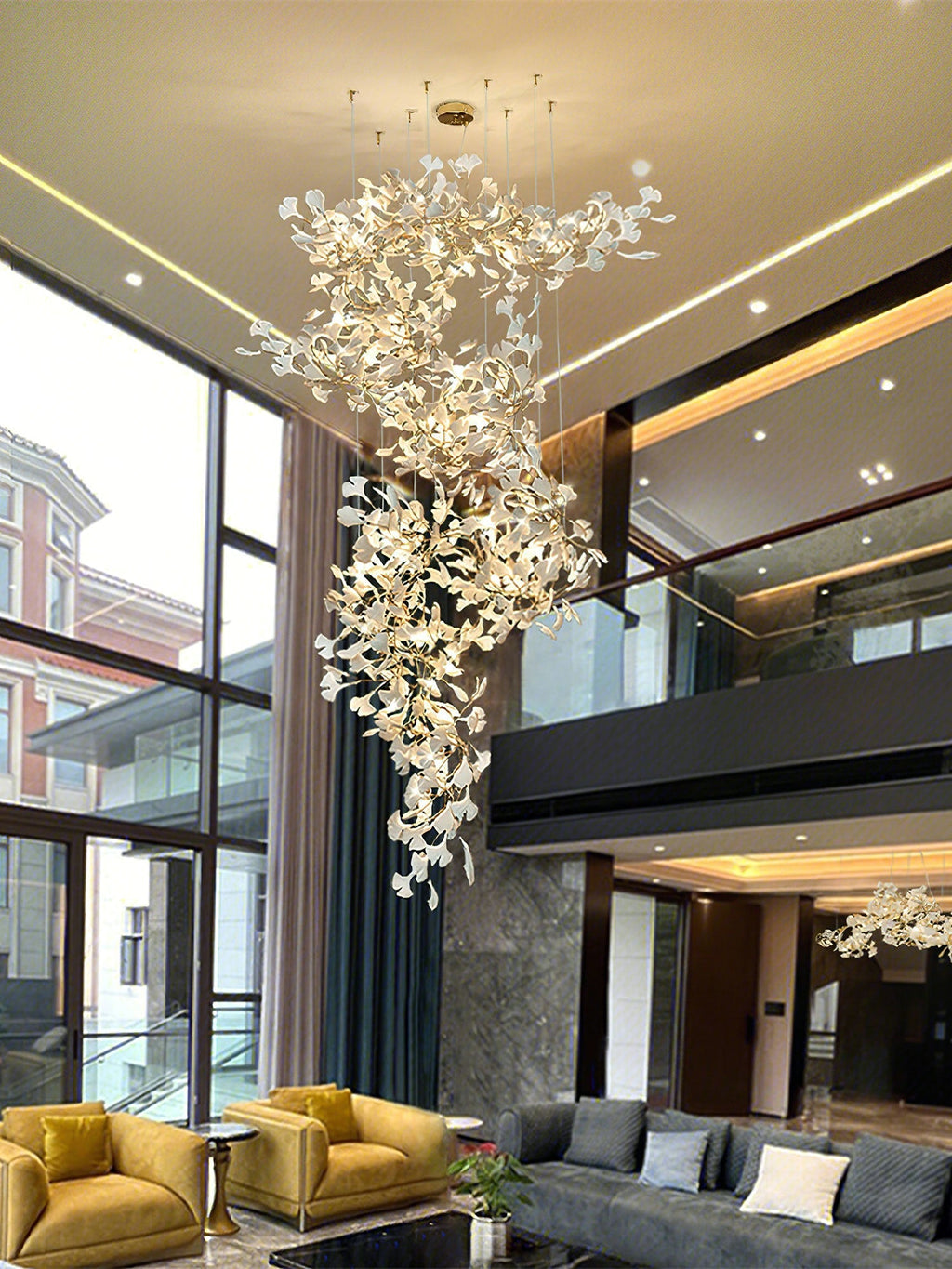 Hung in a double-height lobby beside full-height glazing, yellow sofas and a grey sectional below.