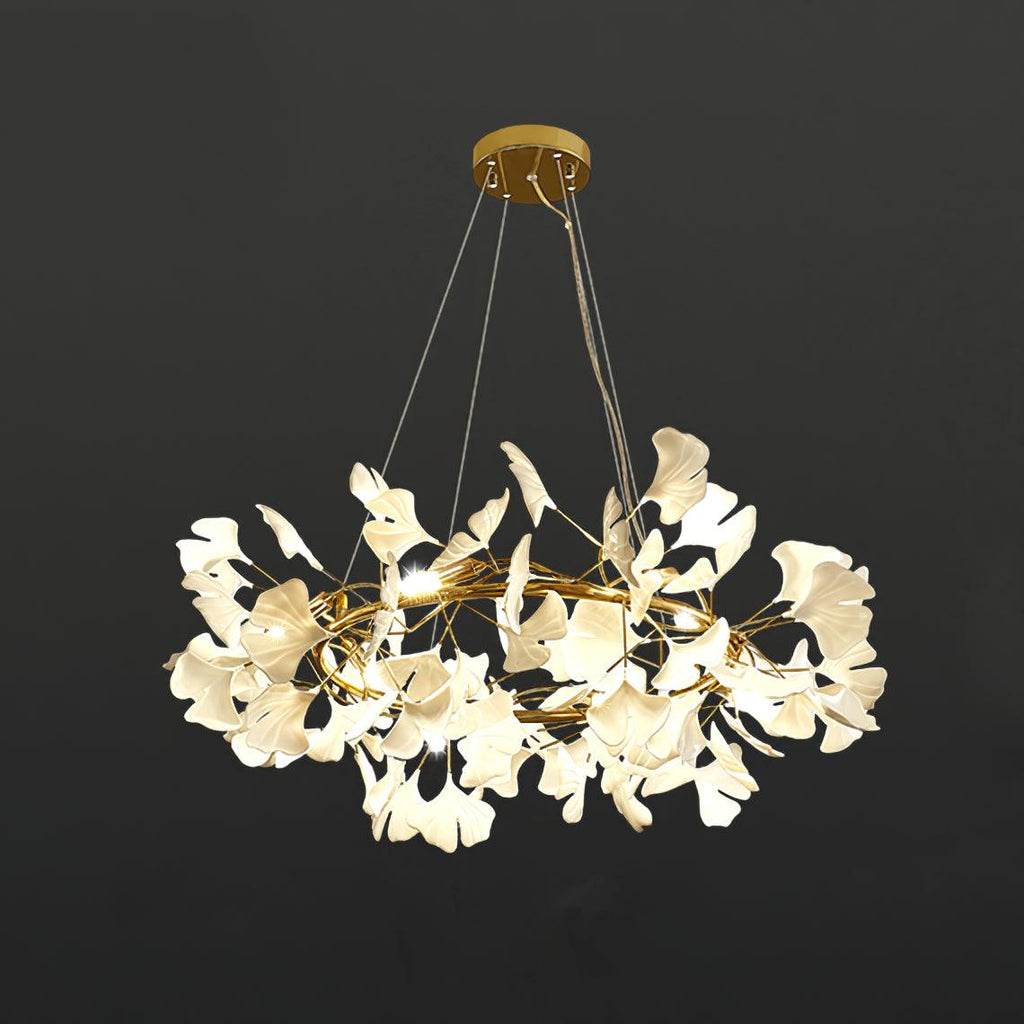 Brass ring chandelier with white porcelain ginkgo leaves lit warm