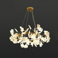 Brass ring chandelier with white porcelain ginkgo leaves lit warm