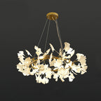 Brass ring chandelier with white porcelain ginkgo leaves lit warm