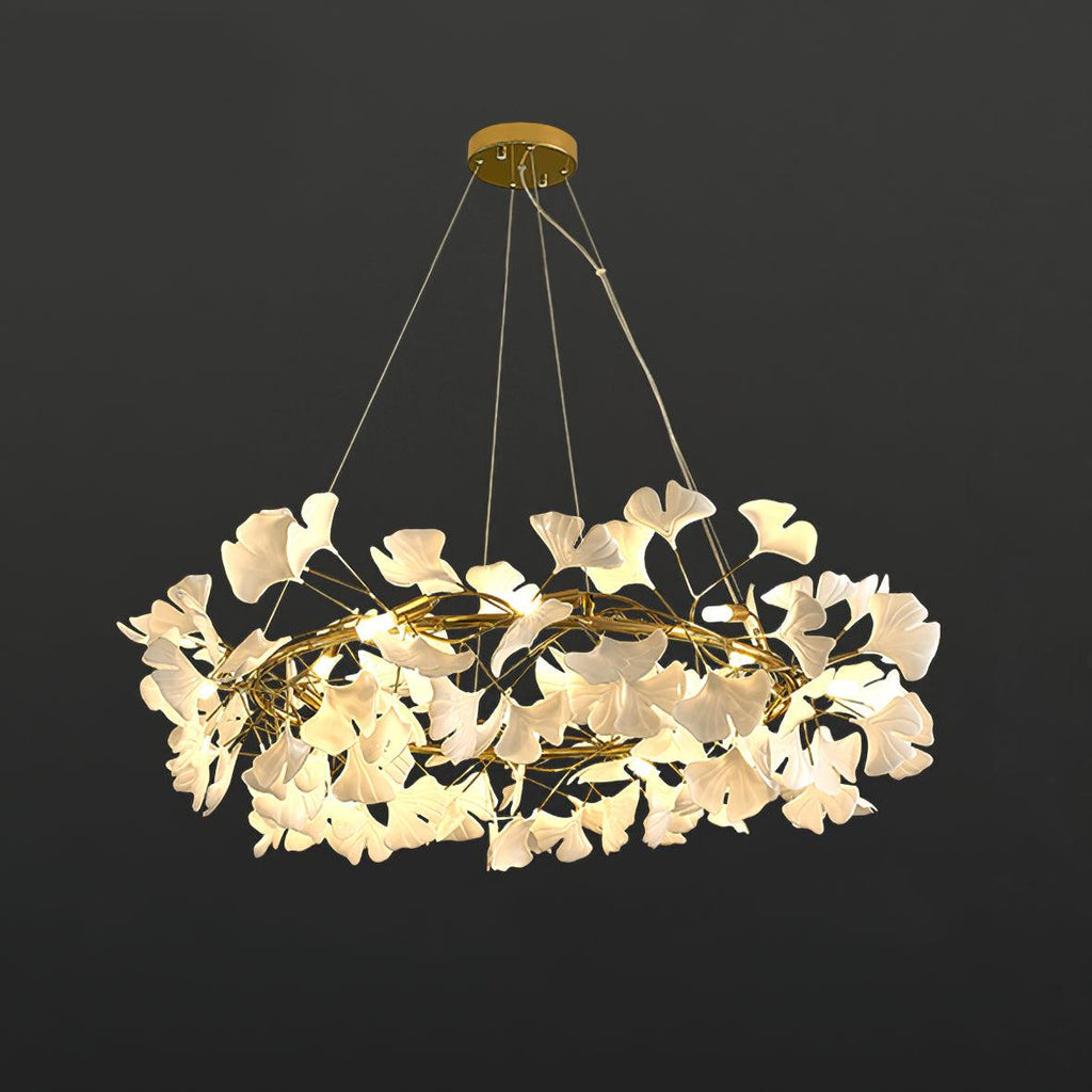 Round brass chandelier crowned with white porcelain ginkgo leaves