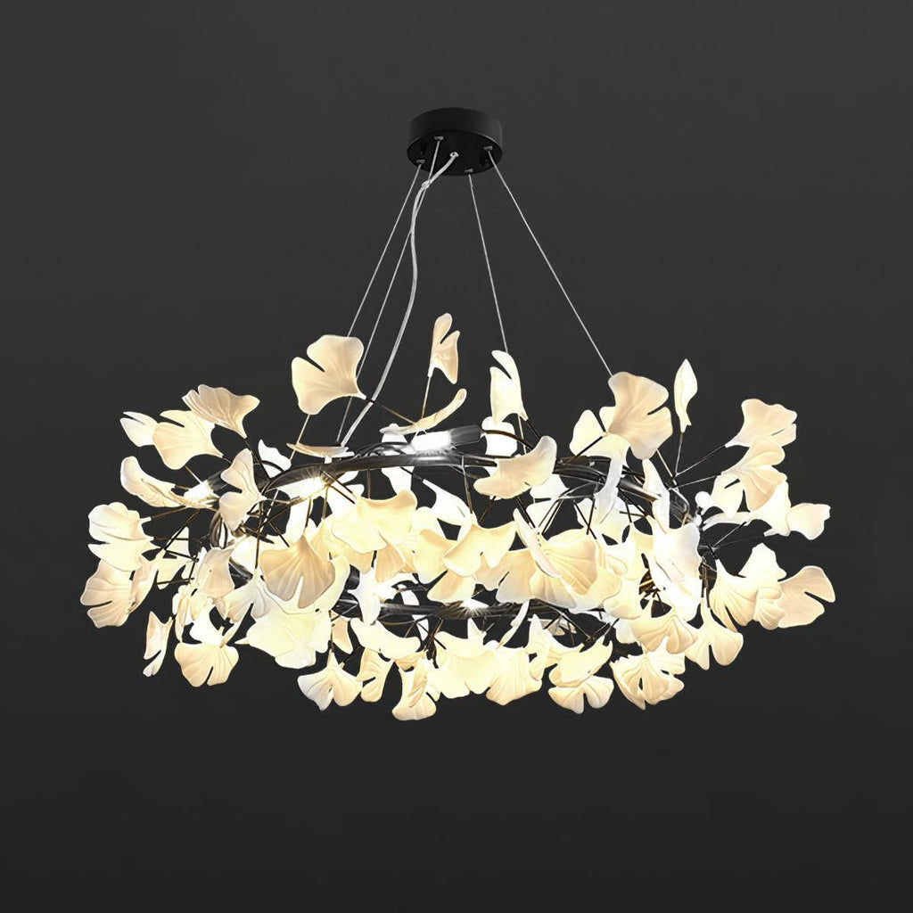 Ginkgo leaf chandelier lit warmly over a styled dining room