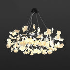 Ginkgo leaf chandelier lit warmly over a styled dining room