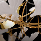 Long chandelier of white leaves glowing in a warm room