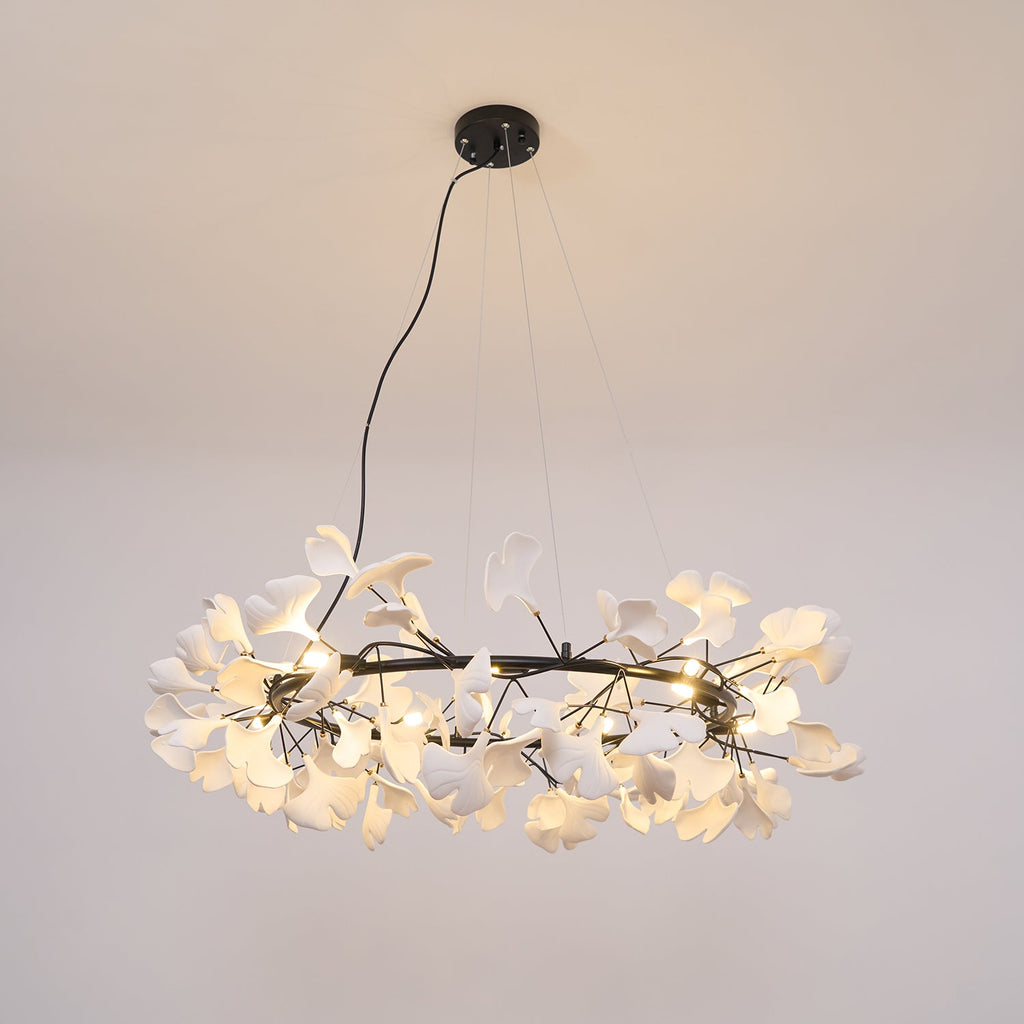 Porcelain ginkgo leaf chandelier glowing above a styled room