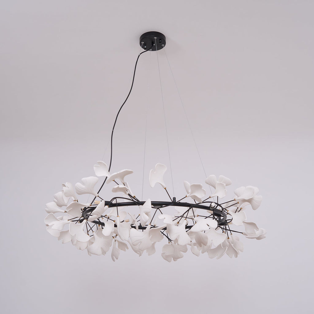 White porcelain ginkgo chandelier lit warmly over a table