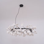 White porcelain ginkgo chandelier lit warmly over a table