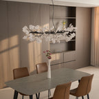 Brass ring chandelier with white porcelain leaves lit warm