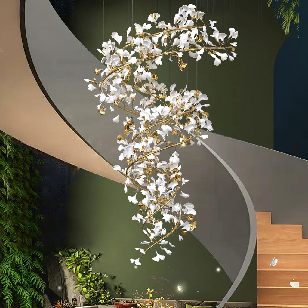 The chandelier spiralling down a double-height stairwell beside a curved white staircase and a deep green wall.