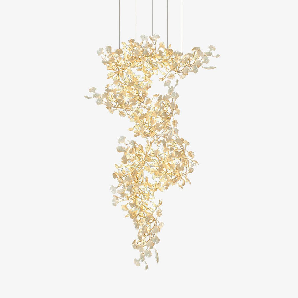 The gingko chandelier on white, gold branches spiralling down in a column hung with porcelain leaves.