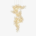 The gingko chandelier on white, gold branches spiralling down in a column hung with porcelain leaves.