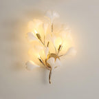 Ceramic ginkgo leaf wall lamp glowing warm on a wall
