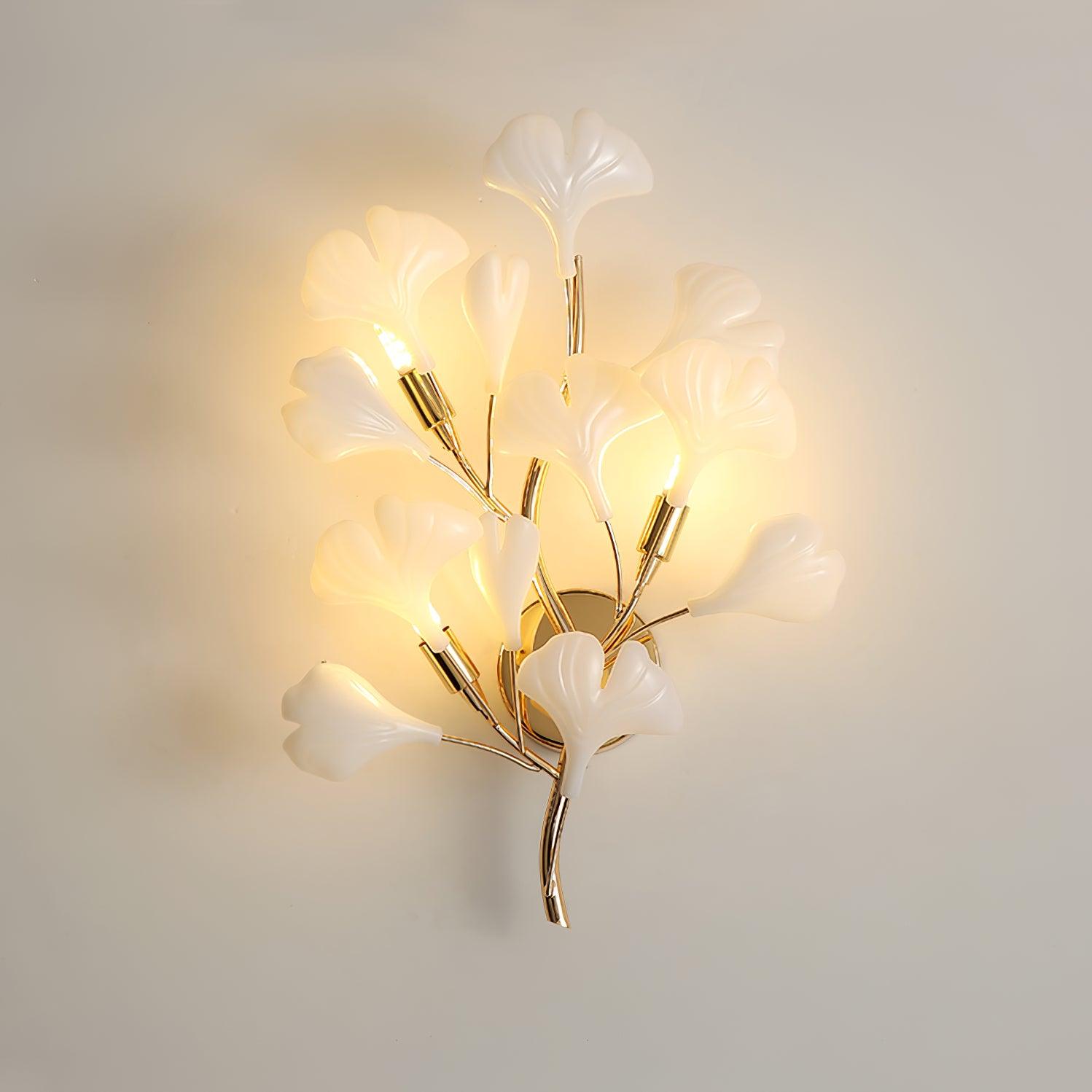 Ceramic ginkgo leaf wall lamp glowing warm on a wall
