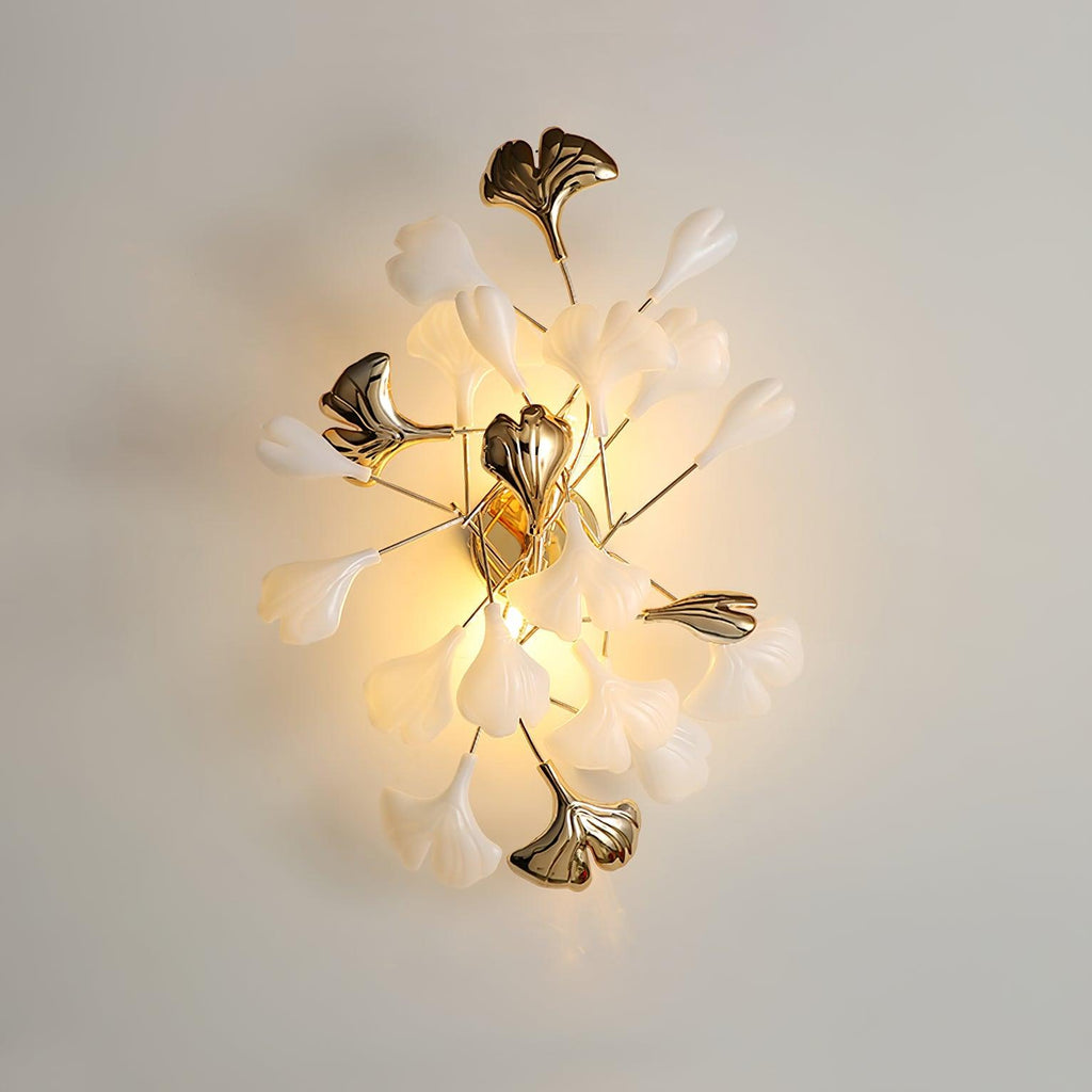 Gold ginkgo leaf wall lamp glowing softly on a wall