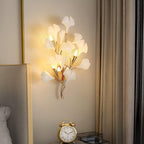 Gold ceramic ginkgo leaf wall lamp on a pale wall