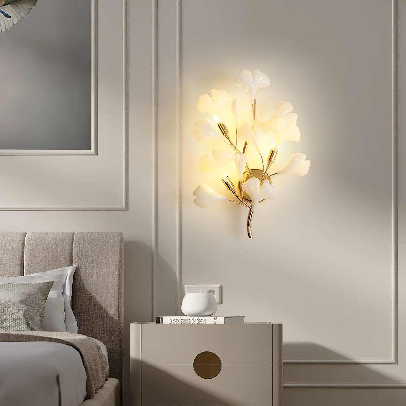 Ceramic ginkgo leaf wall lamp lit softly on a wall