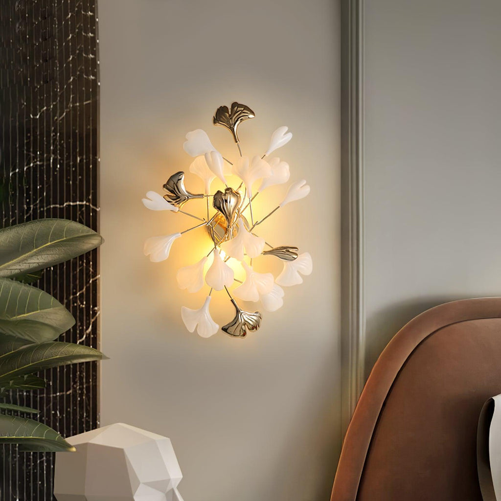 White ceramic ginkgo leaves on a glowing wall lamp
