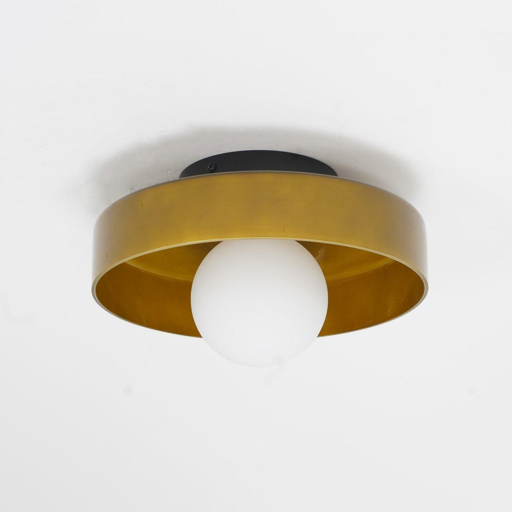 Close view of this Clérachic ceiling light in warm brown glass, its ball unlit against a pale wall.