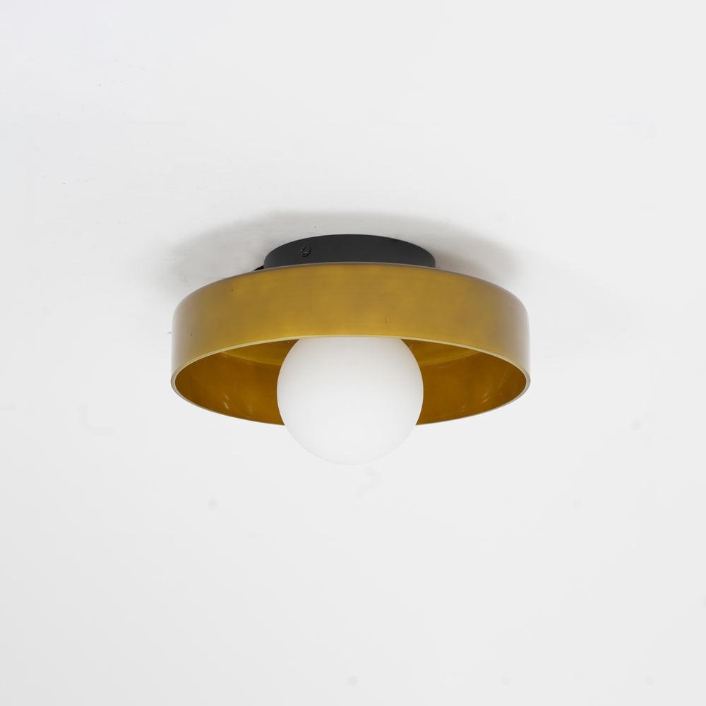 Photographed against a plain wall, this Clérachic ceiling light in warm brown glass sits unlit with its mounting plate visible.