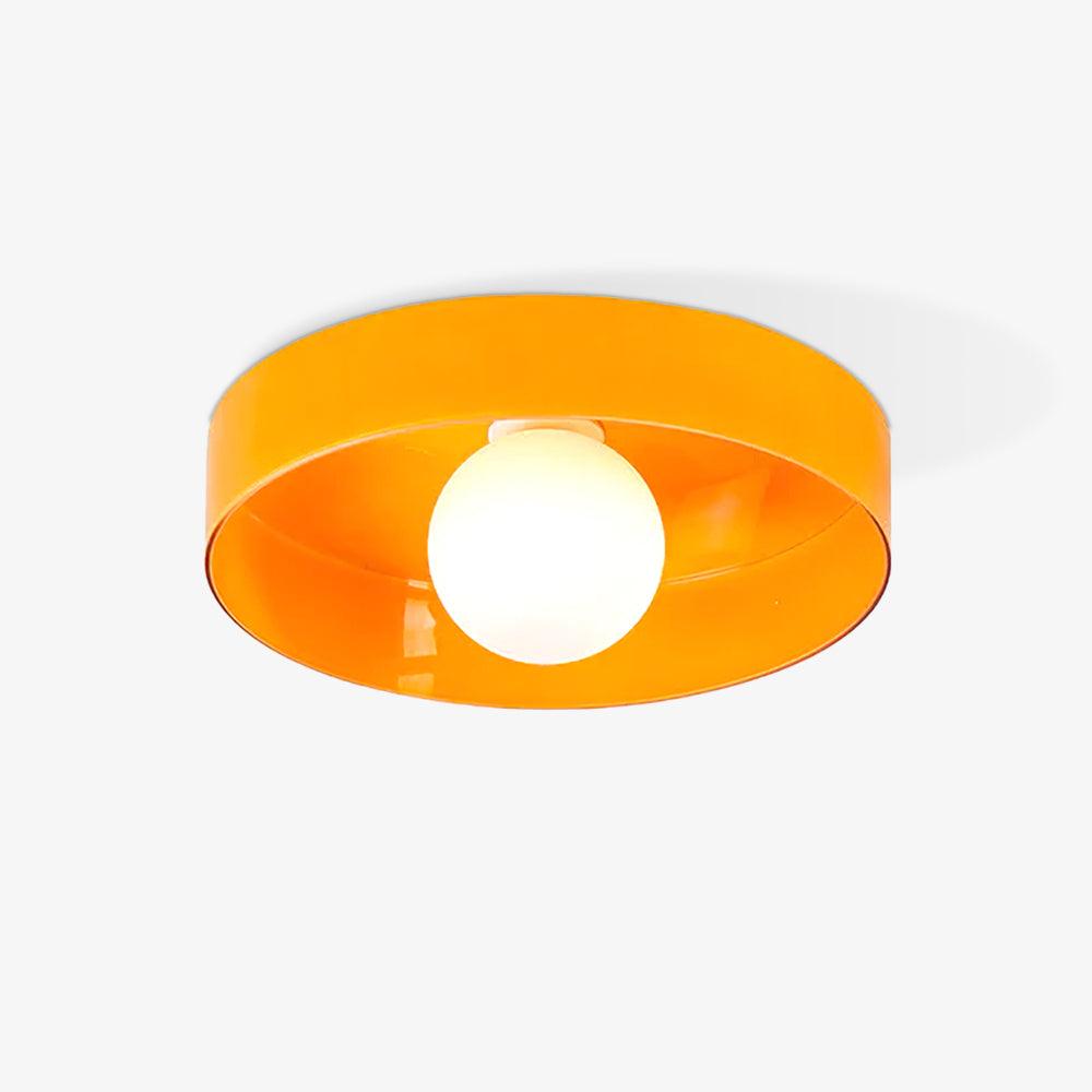This Clérachic orange ceiling light photographed head-on, its white ball resting just off-centre.