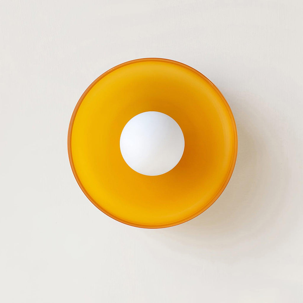 An orange disc-shaped wall light photographed straight on, a different mount from this Clérachic ceiling light.