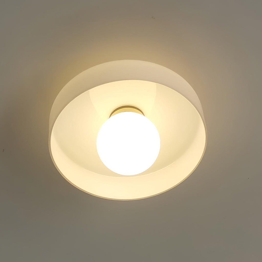 Close view of this Clérachic ceiling light in white glass, its ball lit and glowing warmly beneath the shade.
