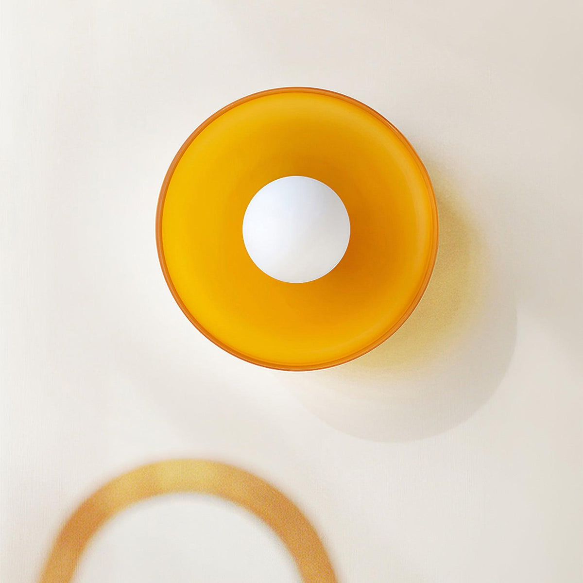 Close-up of an orange disc wall light with a visible mounting arm, a different fixture from this Clérachic ceiling light.