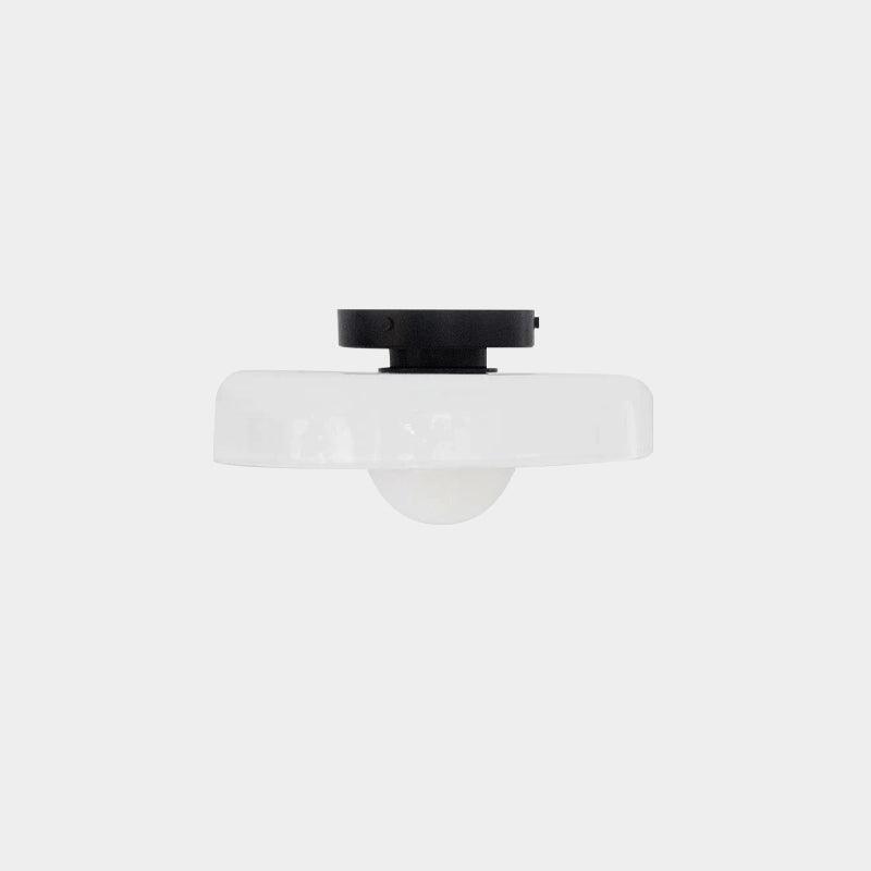The mounting plate and shade of this Clérachic ceiling light shown apart, seen from below on a plain backdrop.