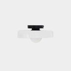 The mounting plate and shade of this Clérachic ceiling light shown apart, seen from below on a plain backdrop.