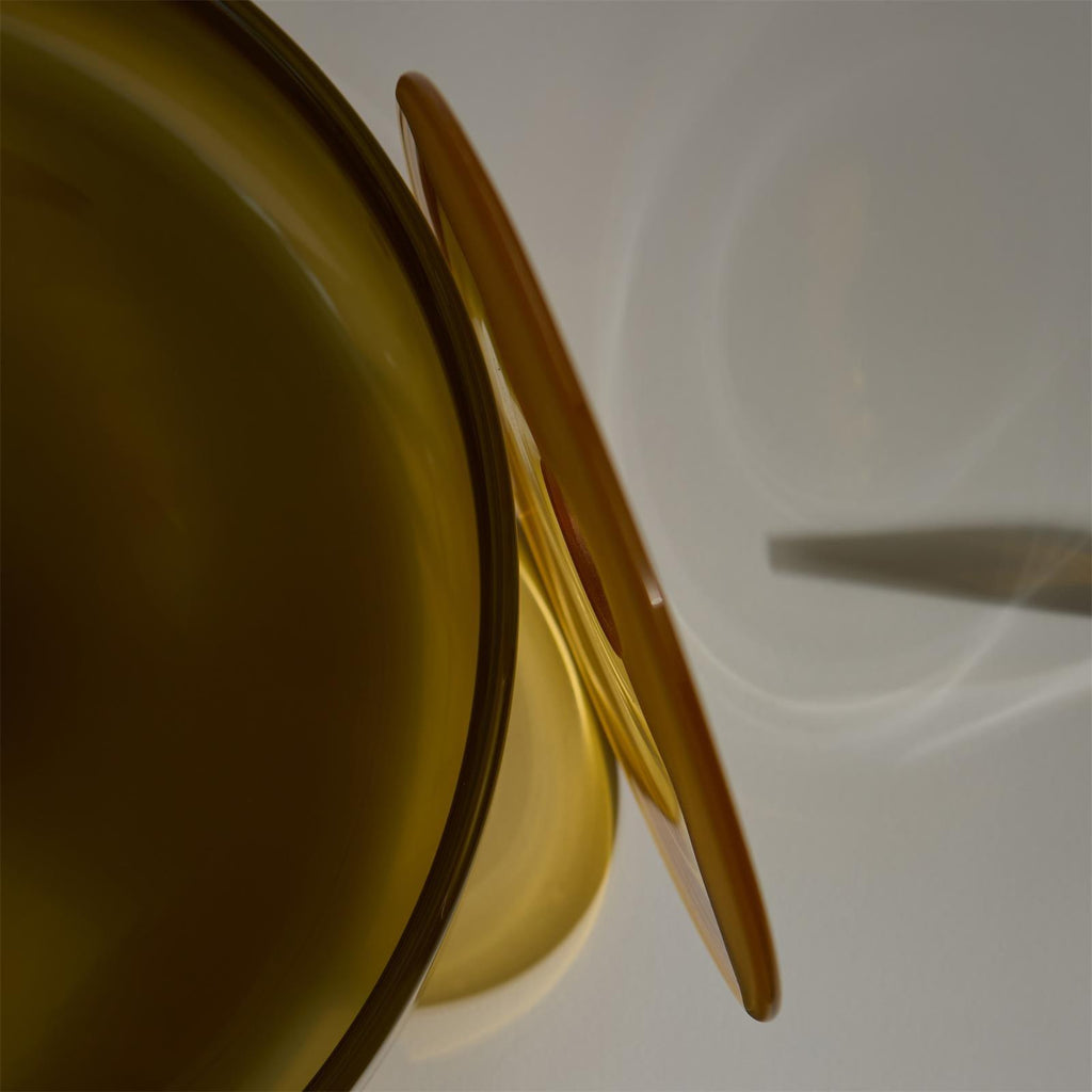 Macro detail of the curved rim of a brown glass shade from this Clérachic ceiling light.